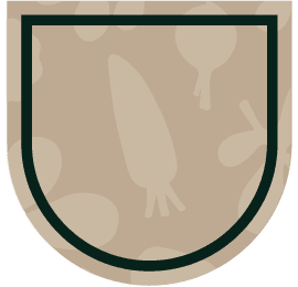 The image shows a beige shield-like emblem with a dark green border. The background features faint vegetable silhouettes, including a carrot, onion, and other root vegetables.