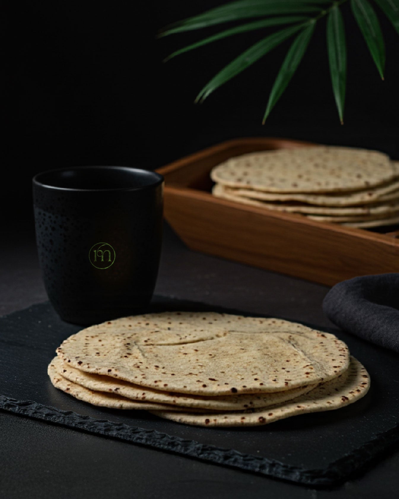 Arabic Flat Bread - Zero-Sugar - High Protein - Low Carb by Macromize displayed on a slate board with a stack in a wooden tray. Ideal for healthy wraps or keto meals.
